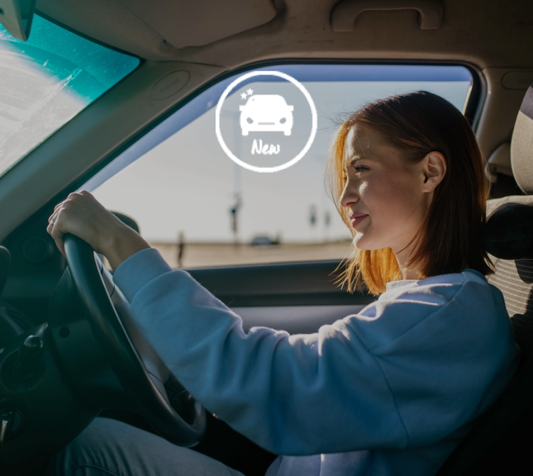 A woman smiling while driving. Find out how you can novated lease on a brand-new car with potential tax savings and benefits.