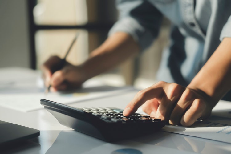 A hand on a calculator. Find out what it costs to operate your car each year with the help of our running cost calculator.