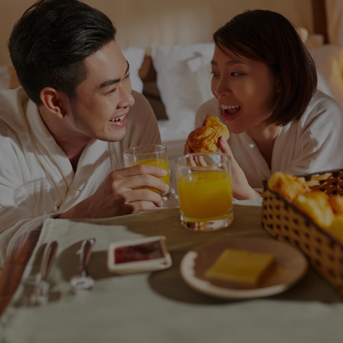 A couple enjoying breakfast on bed - Maxxia Meal Entertainment Banner