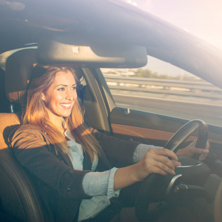 A woman smiling while driving.